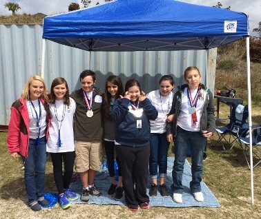 From left to right: Ms. Parker stands next to her student volunteer, McKenzie at the Special Olympic Games hosted at White Knoll High. Participants Taylor, Jackie and Ariel hold their medals.