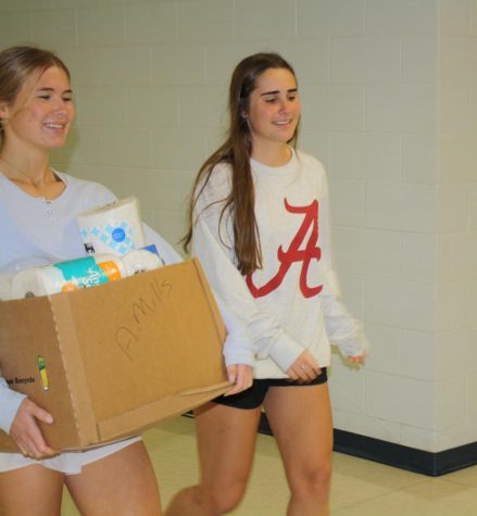 Seniors Leah Cabe and Caroline Carter on the way back to Ms. Williams room from collecting their trick or canning goods from different classes around the school.