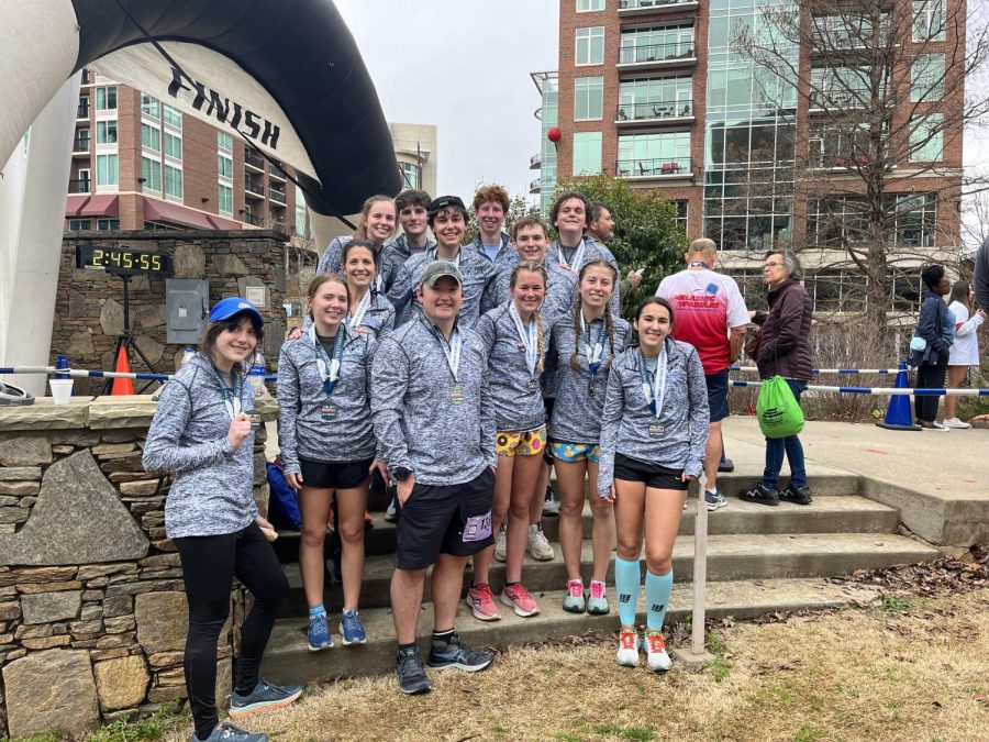 Dr. Latham and Ms. Graham and the students take a photo at the finish line of the half marathon.