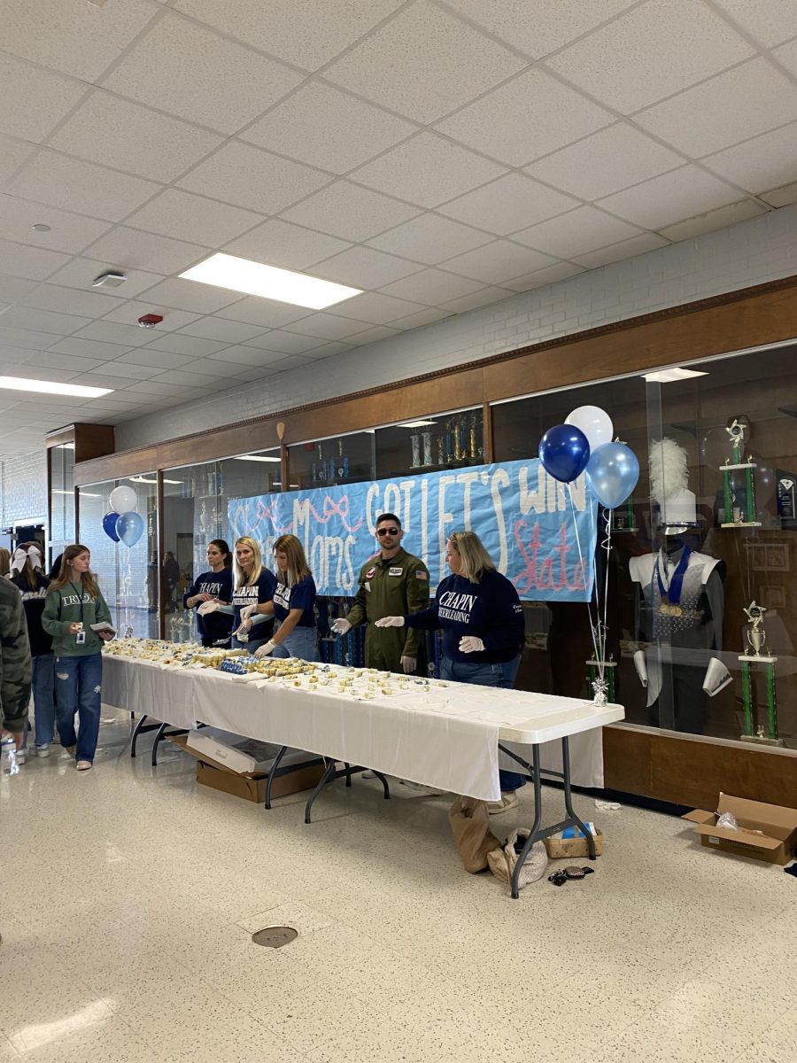 Cheerleading Squad Parents serve cake to the students as the cheering team prepares for the state championship.