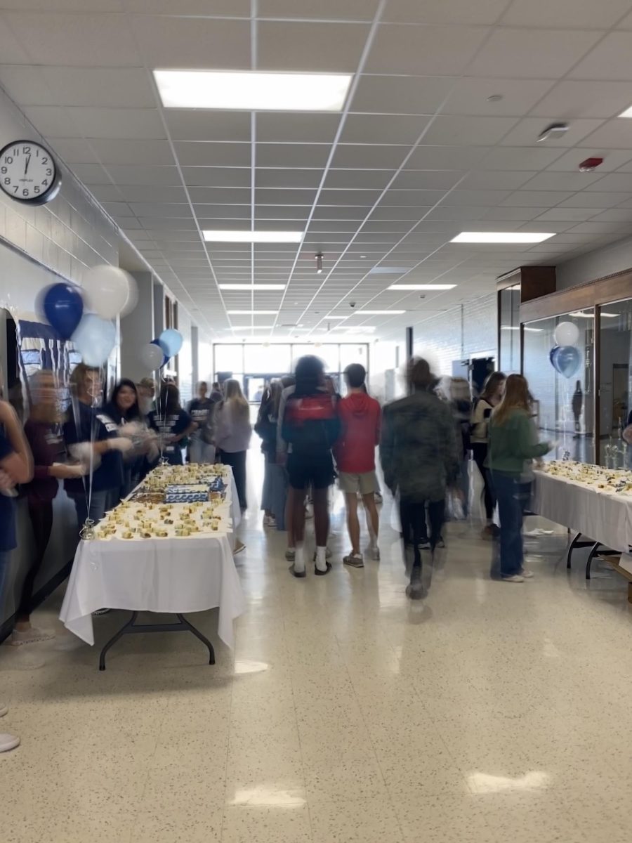 Cheerleading Squad Parents serve cake to the students as the cheering team prepares for the state championship.