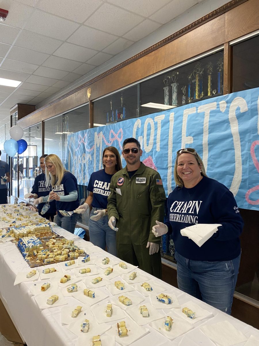 Cheerleading Squad Parents serve cake to the students as the cheering team prepares for the state championship.