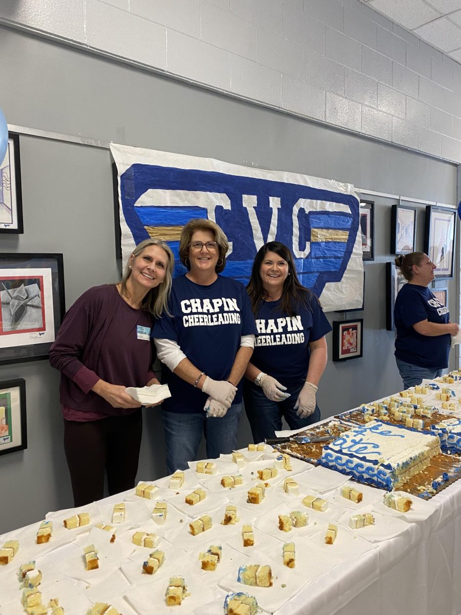 Cheerleading Squad Parents serve cake to the students as the cheering team prepares for the state championship.