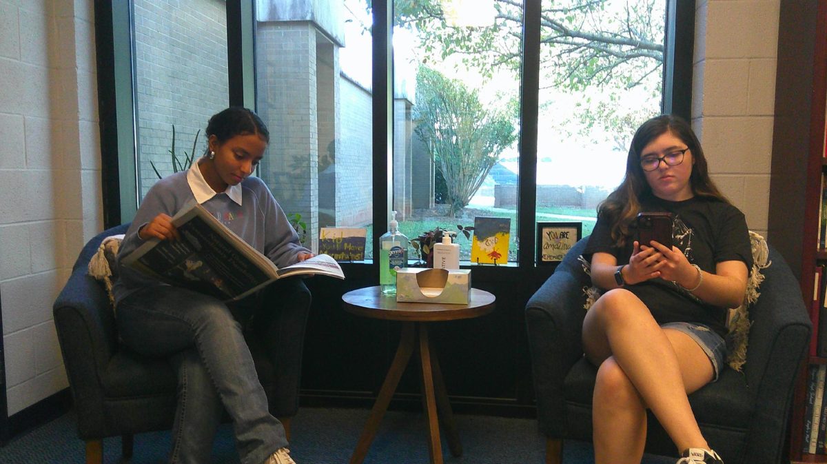 Two students looking at the different types of news.