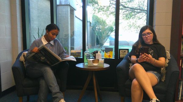 Two students looking at the different types of news.